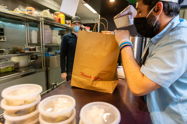 A photo of fast-food workers preparing bags for take out. The low-paying fast food industry has driven the surge in violations of child labor laws, with teens working longer and later than permitted under federal law. (iStock/halbergman)